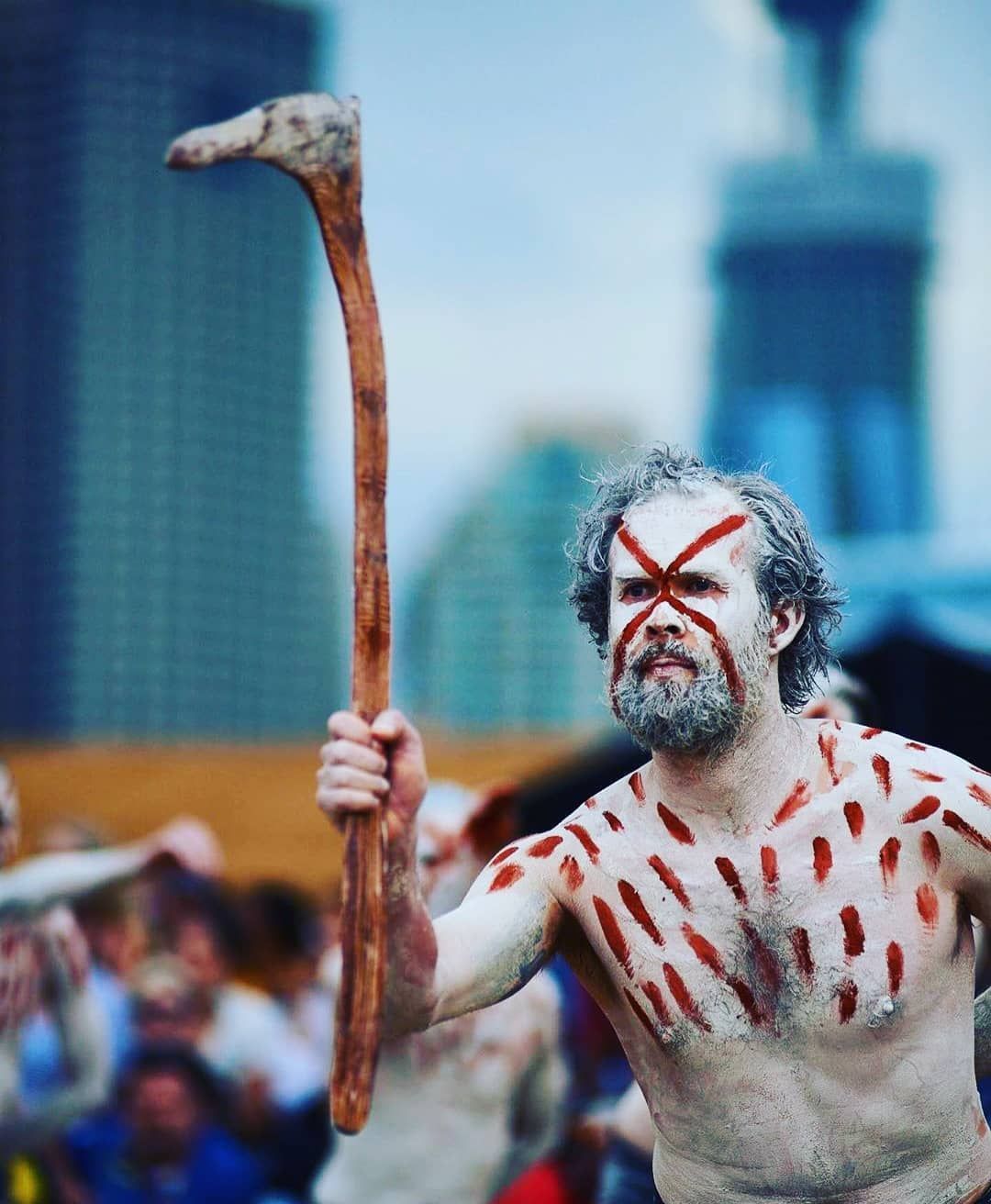 Man Covered in White Clay with Red Markings Holding a Wooden Weapon — Dinawan's Connection in Dubbo, NSW