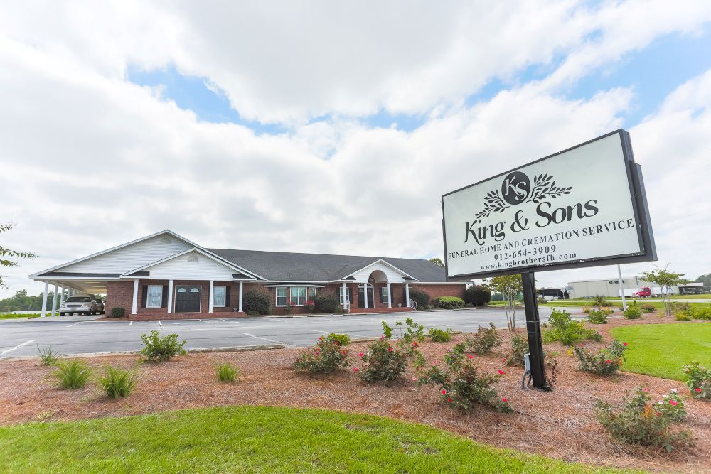 A funeral home with a sign in front of it.