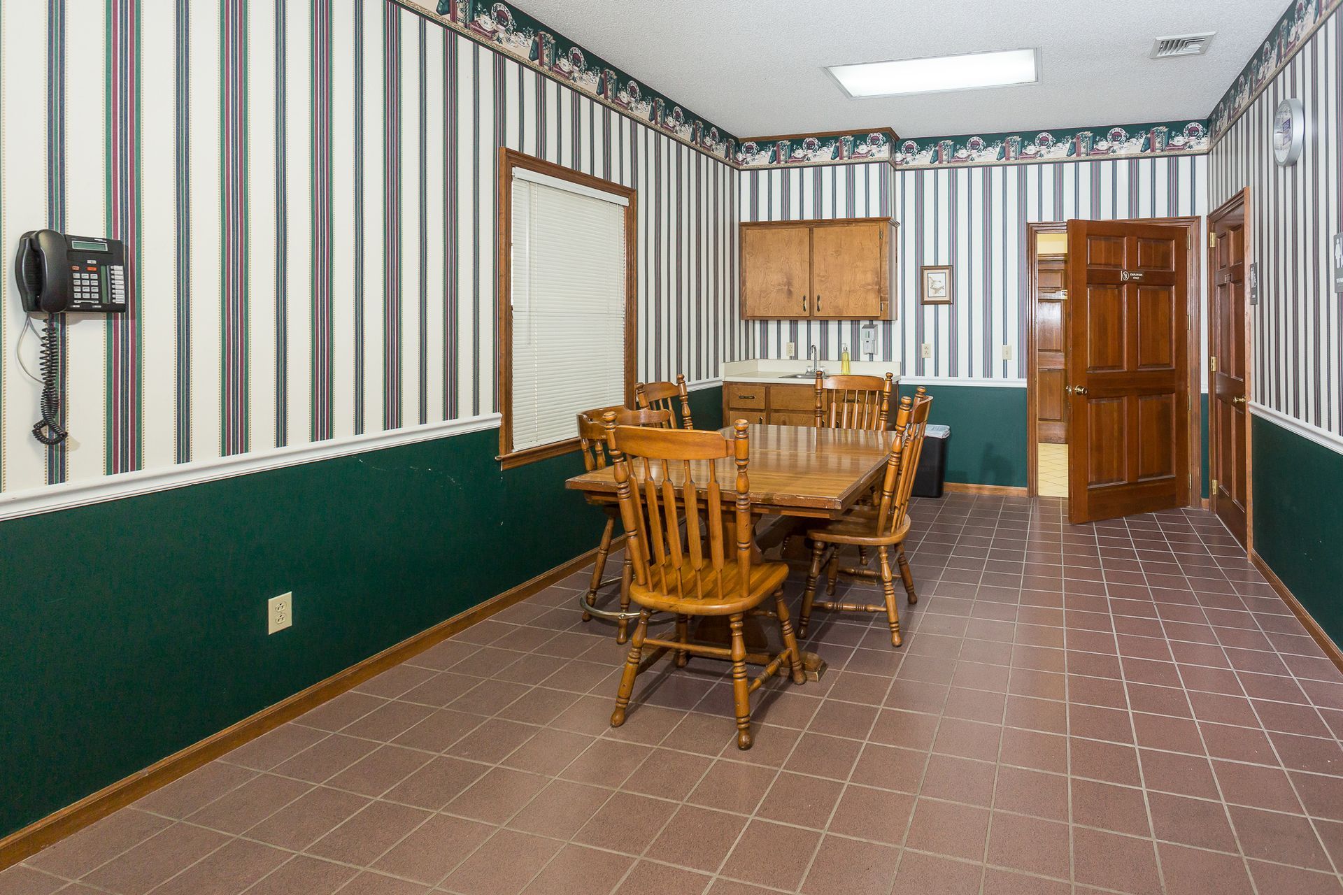 A dining room with a table and chairs and striped walls