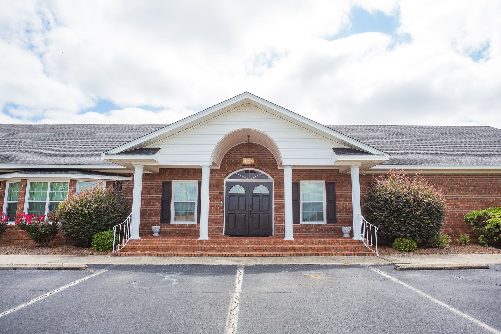 A large brick building with a parking lot in front of it.