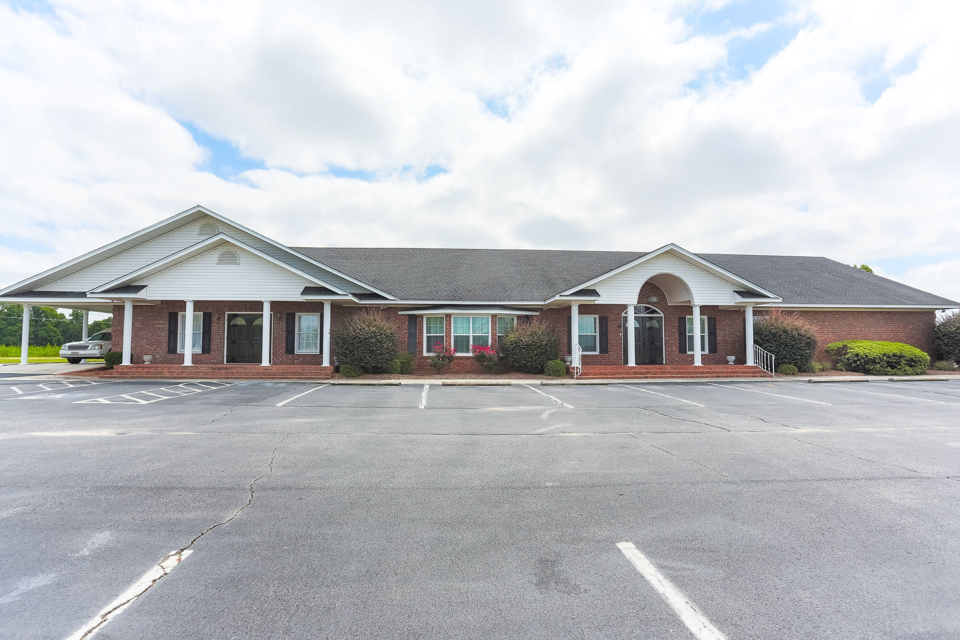 A large building with a lot of cars parked in front of it.