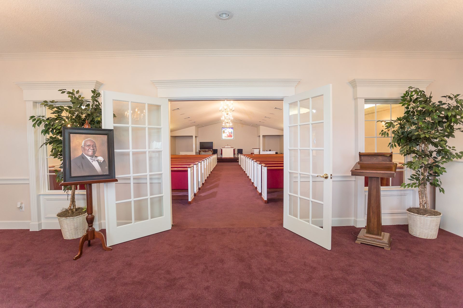 A picture of a man is on a stand in a church.
