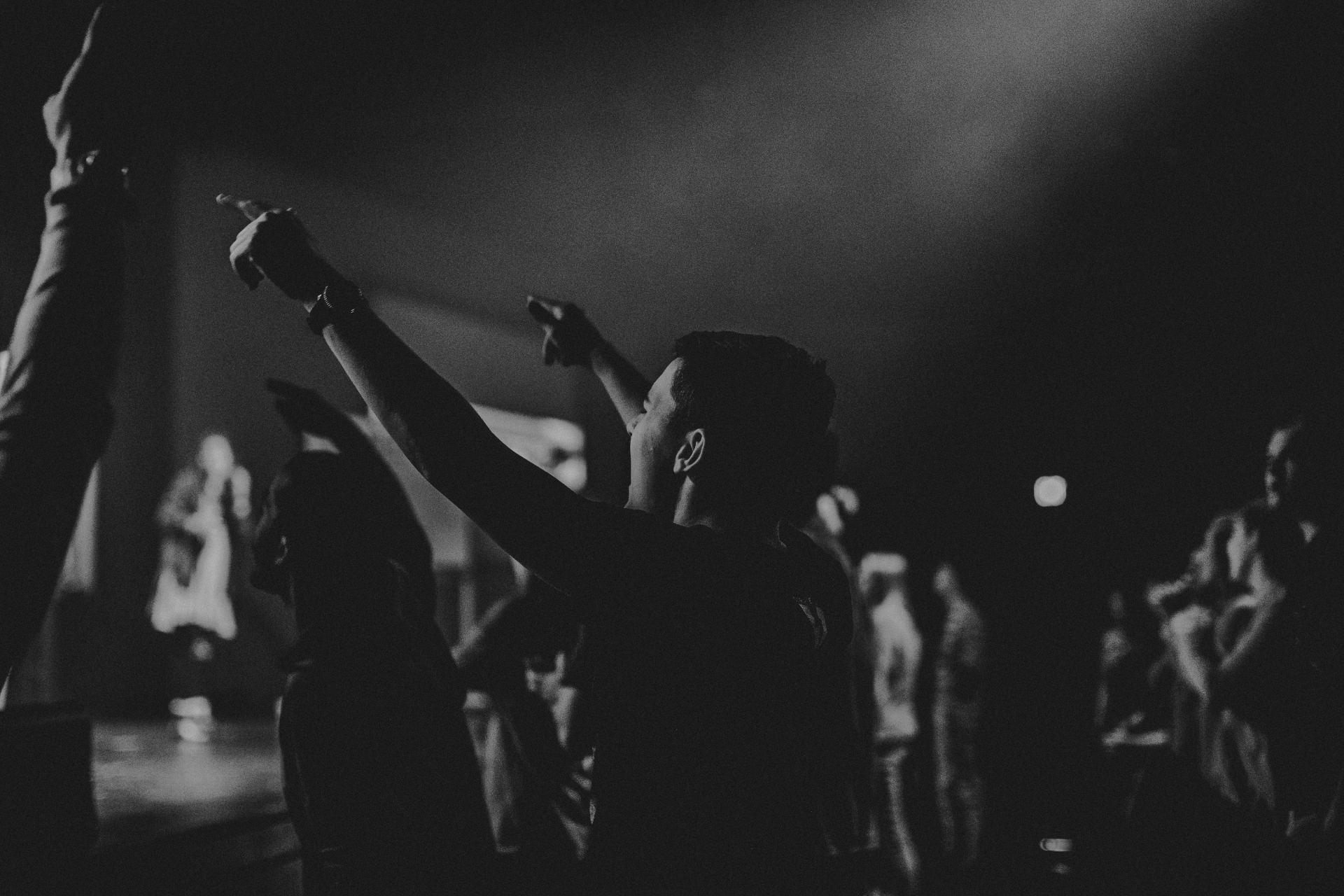 Young Christian Man Worshipping In a Crowd