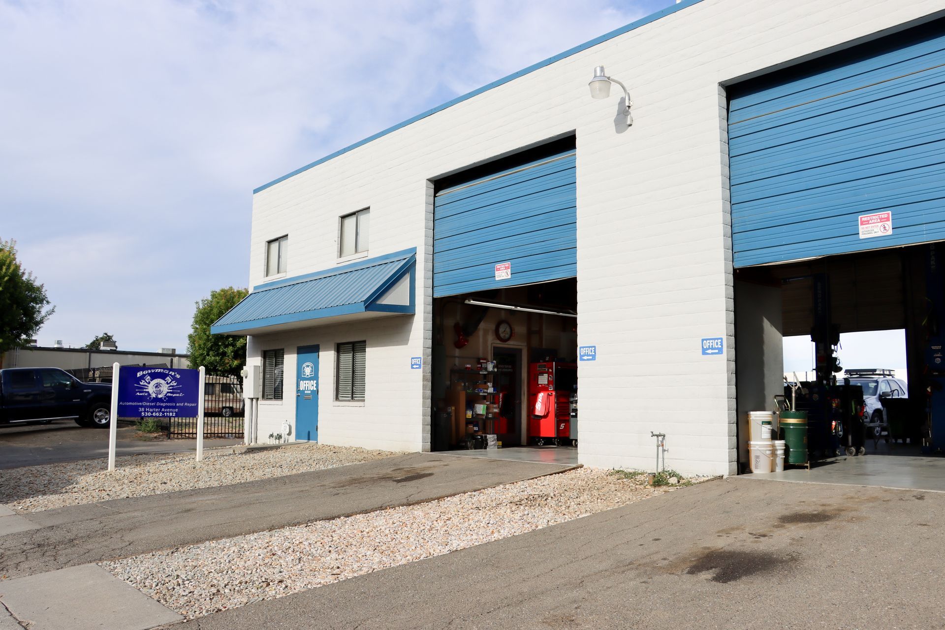 A white building with blue garage doors and a sign that says 305