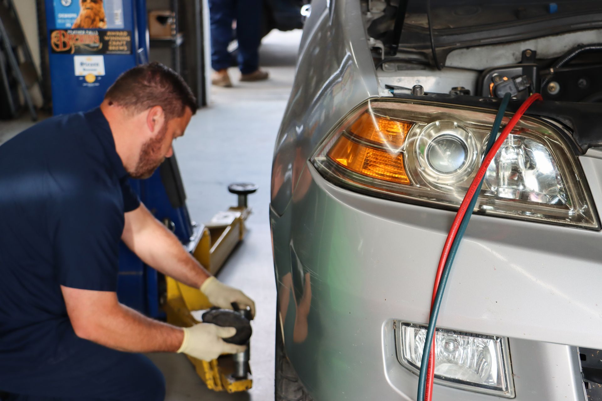 A man is working on a car in a garage.