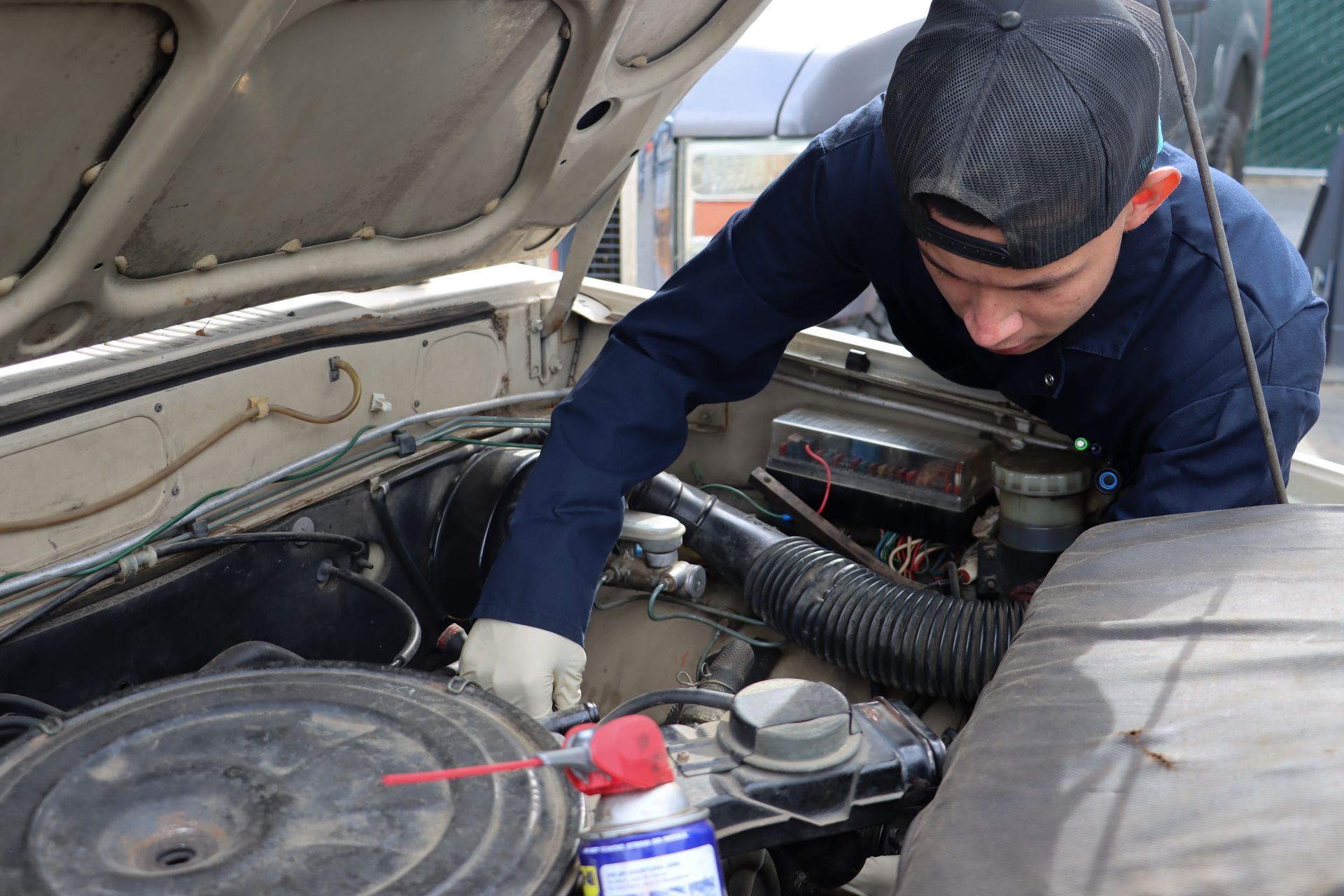 A man is working on the engine of a car.