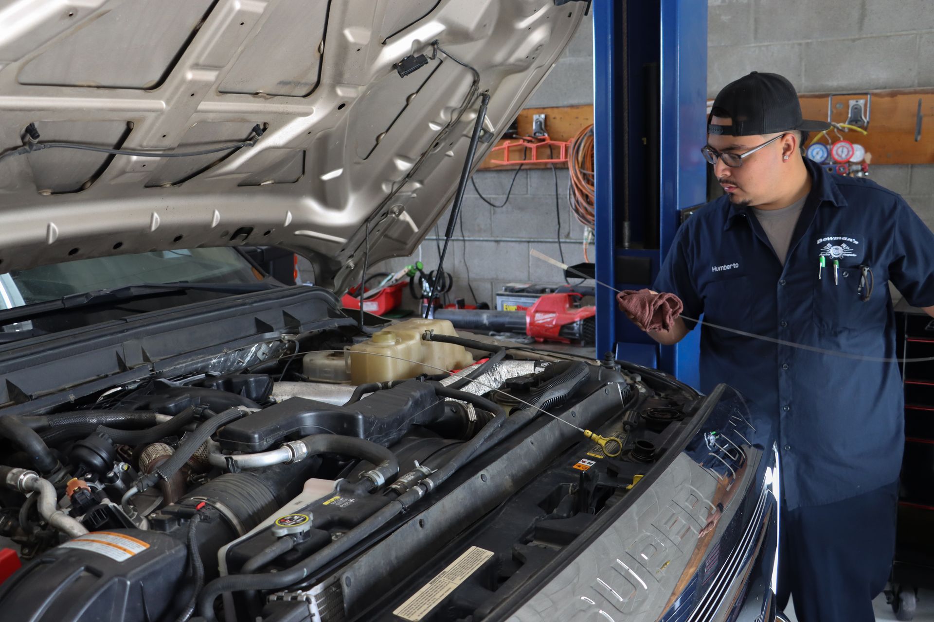A man is working on a car with the hood open