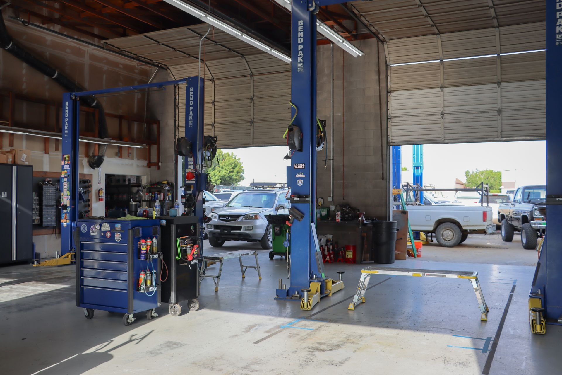 A garage with a lot of cars and trucks in it