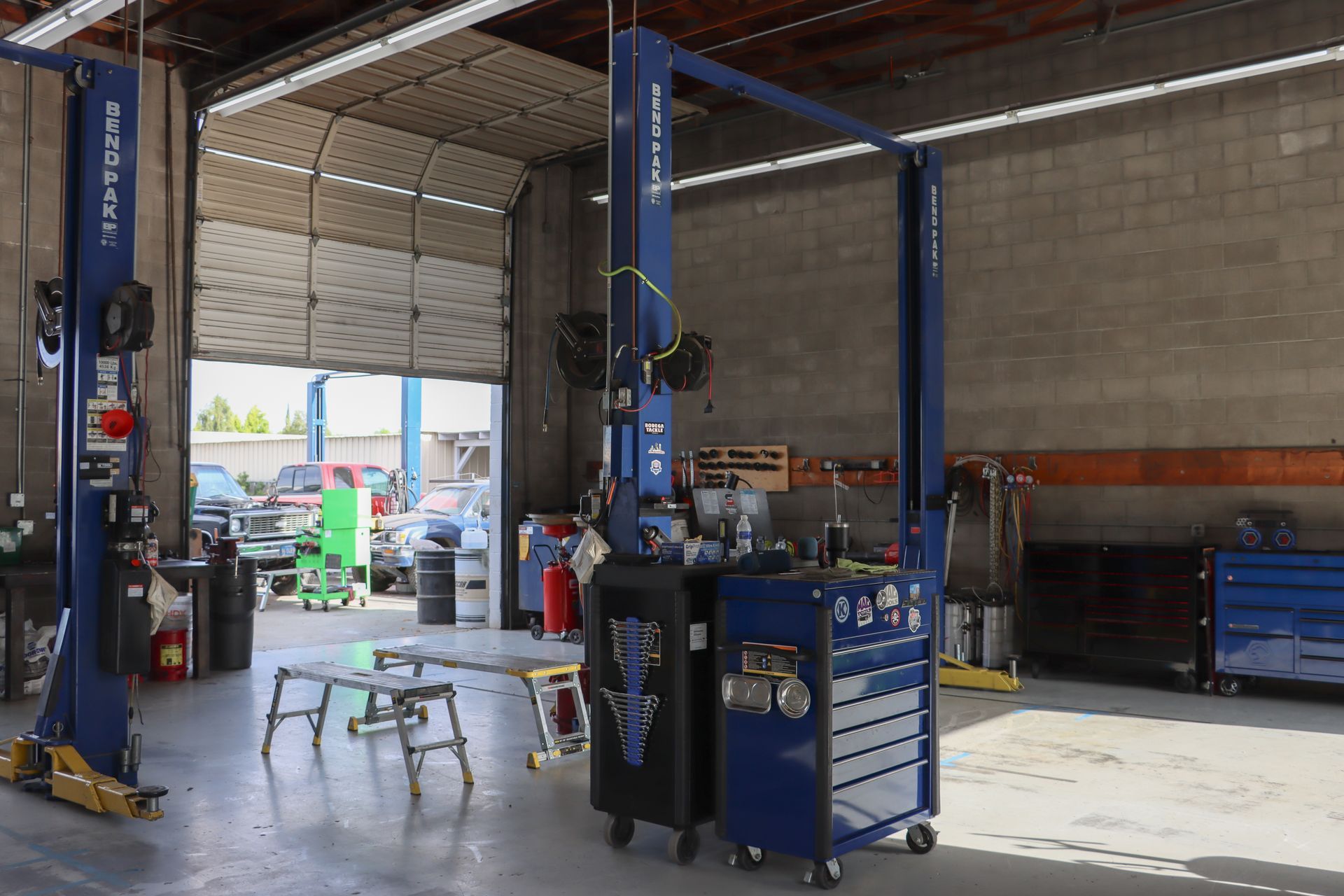 A garage with two lifts and a stool in it