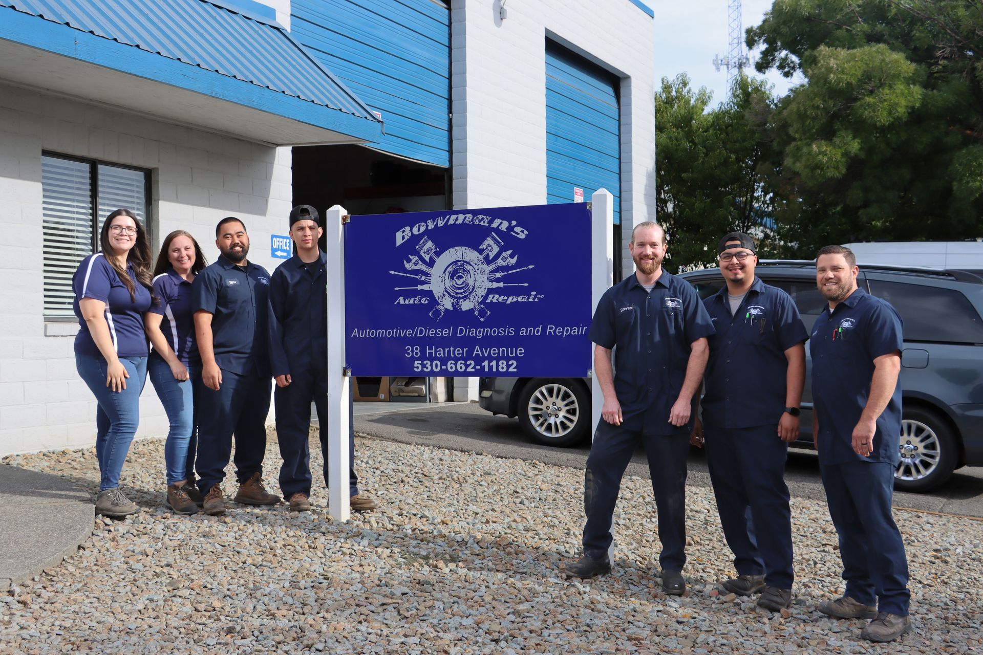A group of people are posing for a picture in front of a building.