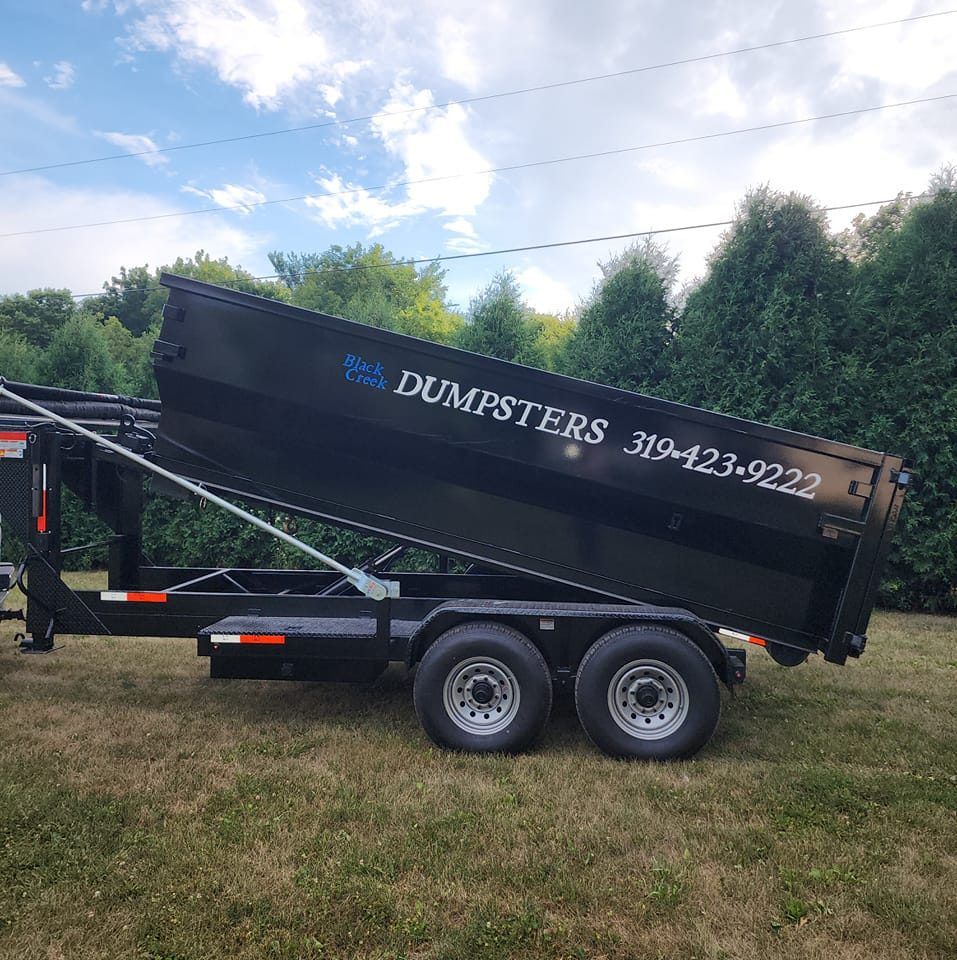Black trailer with dumpster.