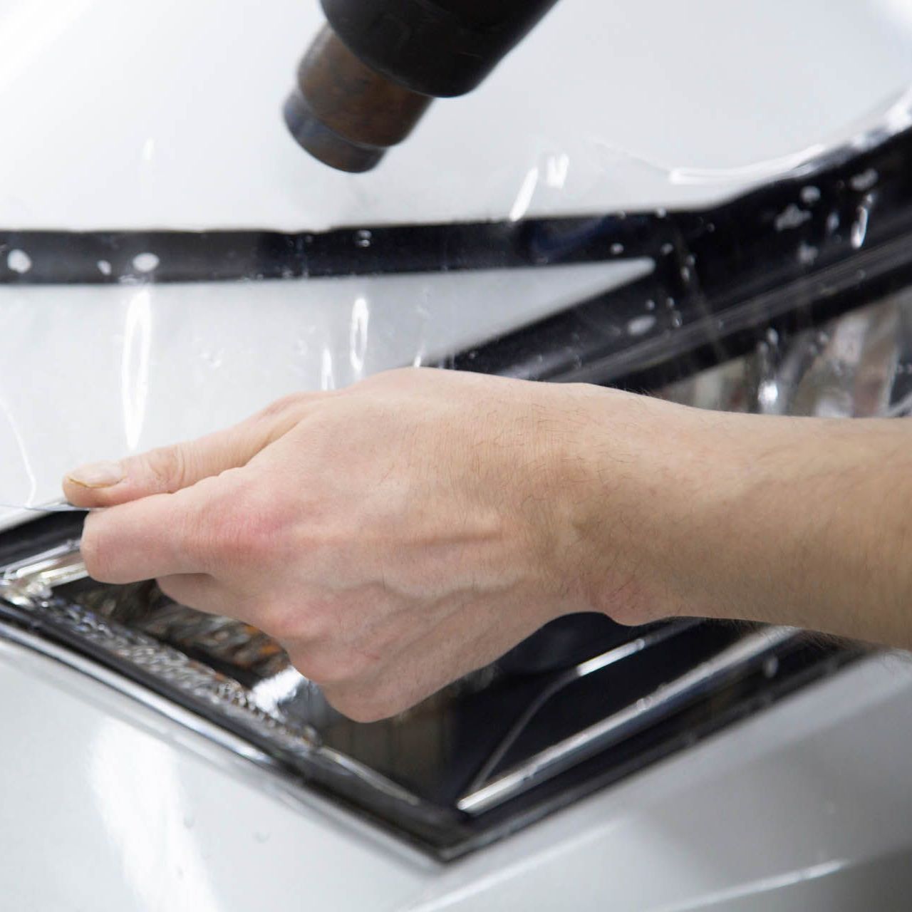 A close up of water drops on the hood of a car