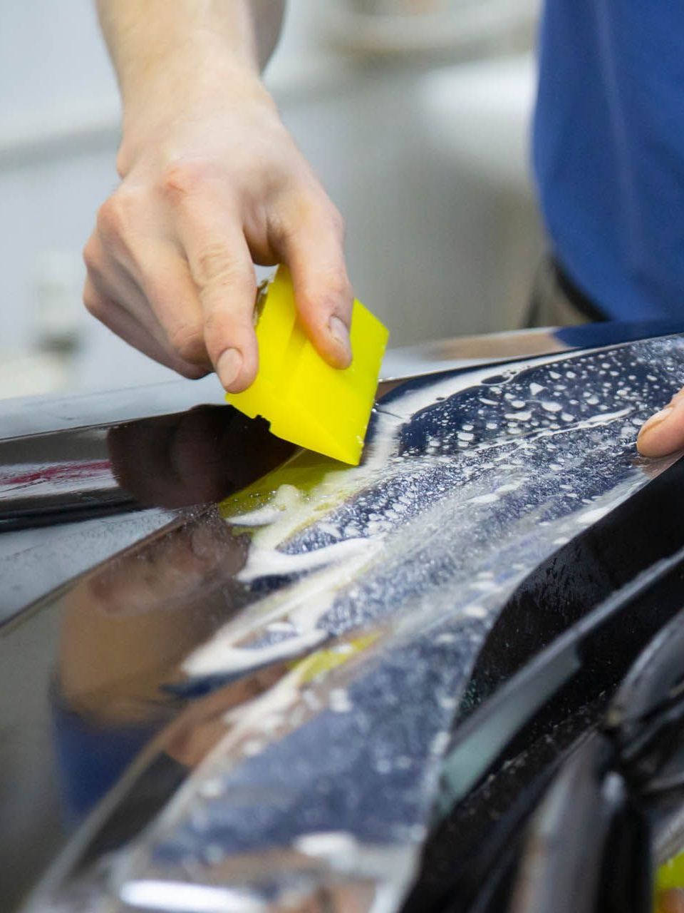 A person is washing a car wheel with foam
