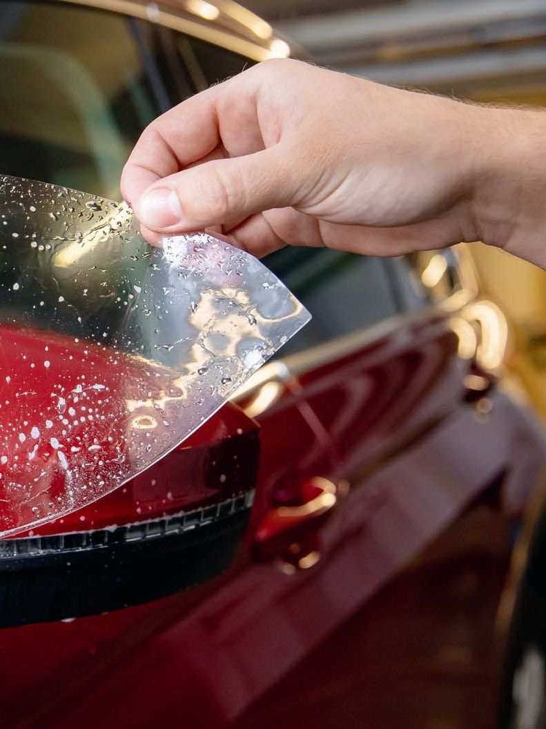 A person is washing a car wheel with foam