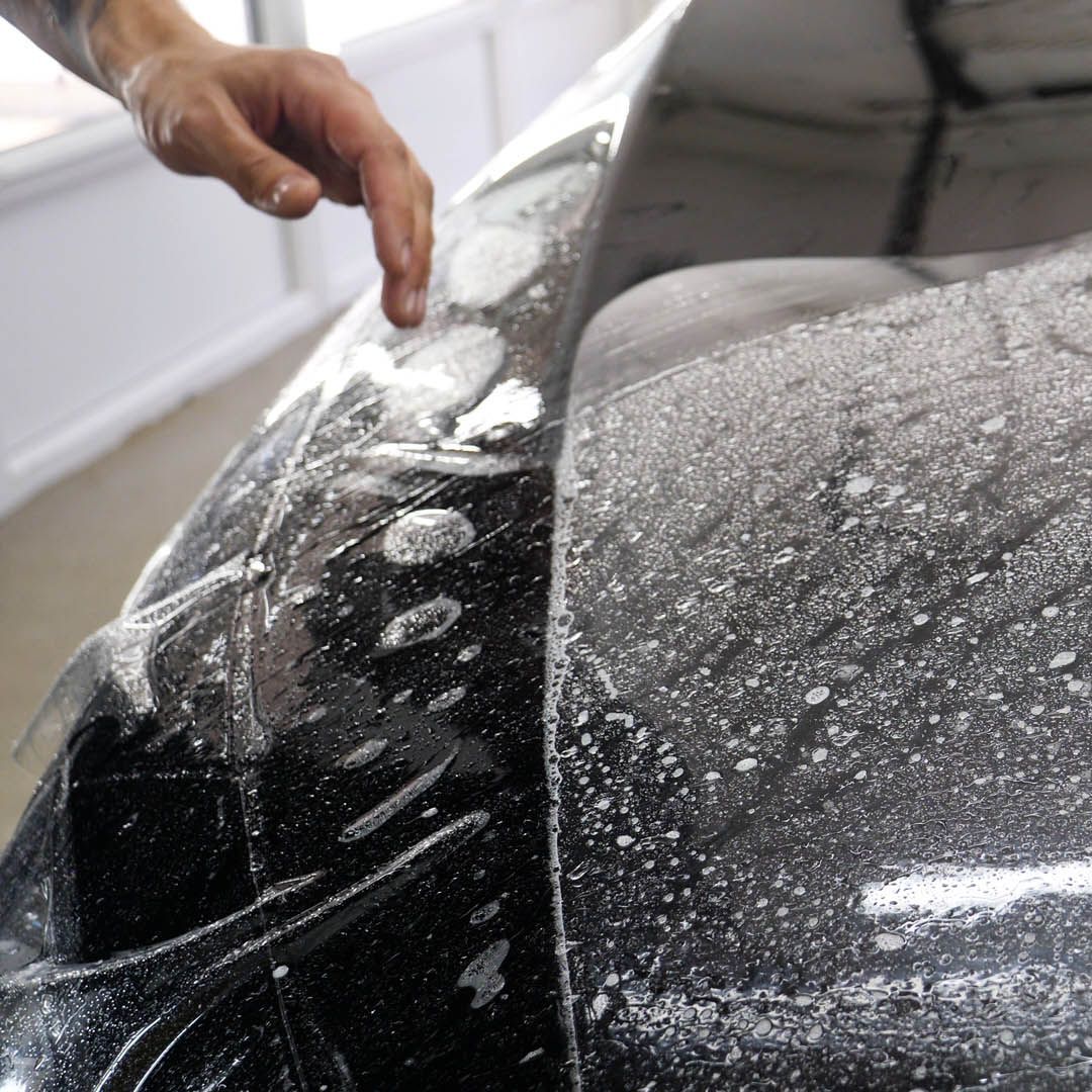 A close up of water drops on the hood of a car