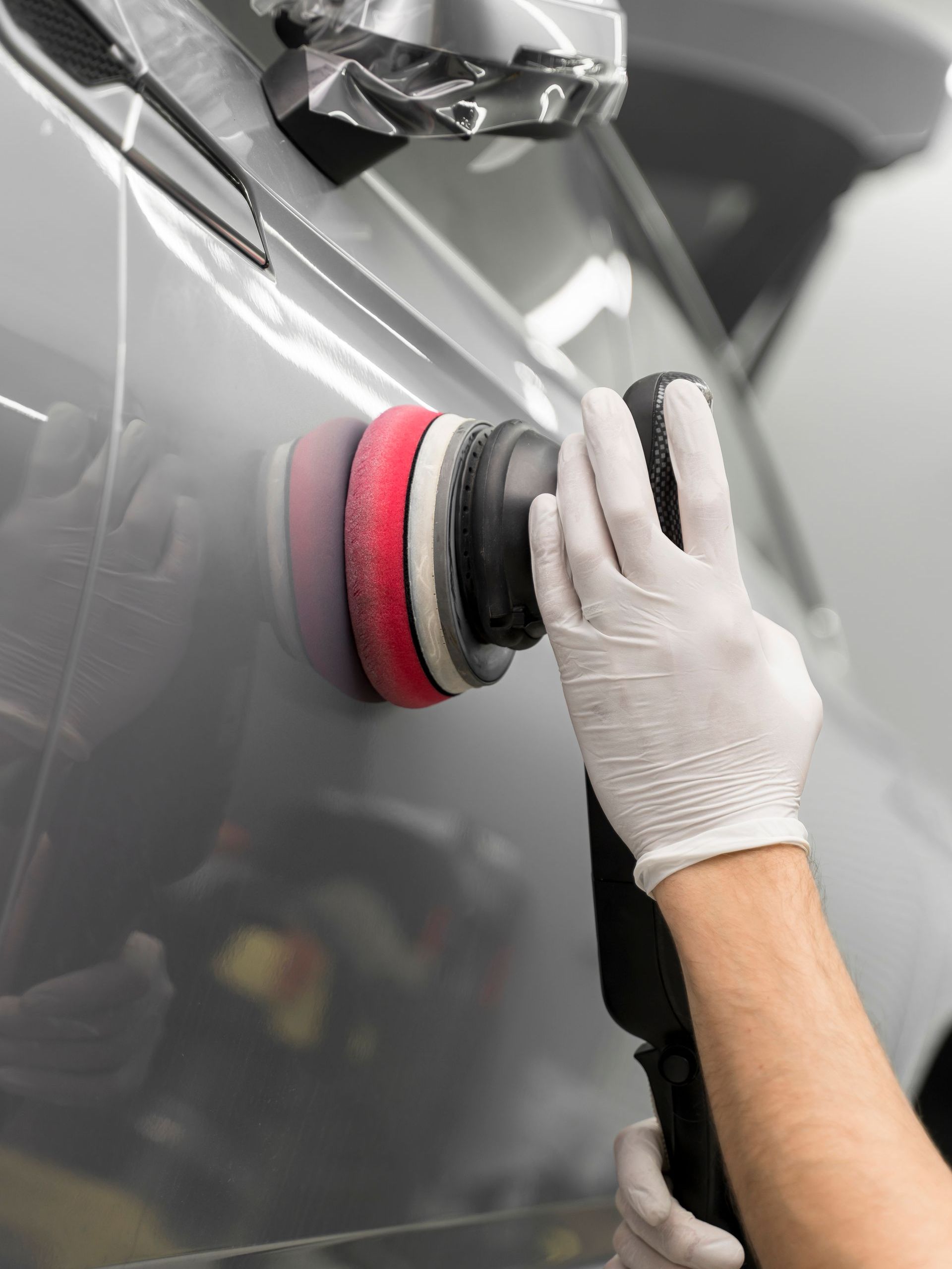 A person is polishing a car with a machine.
