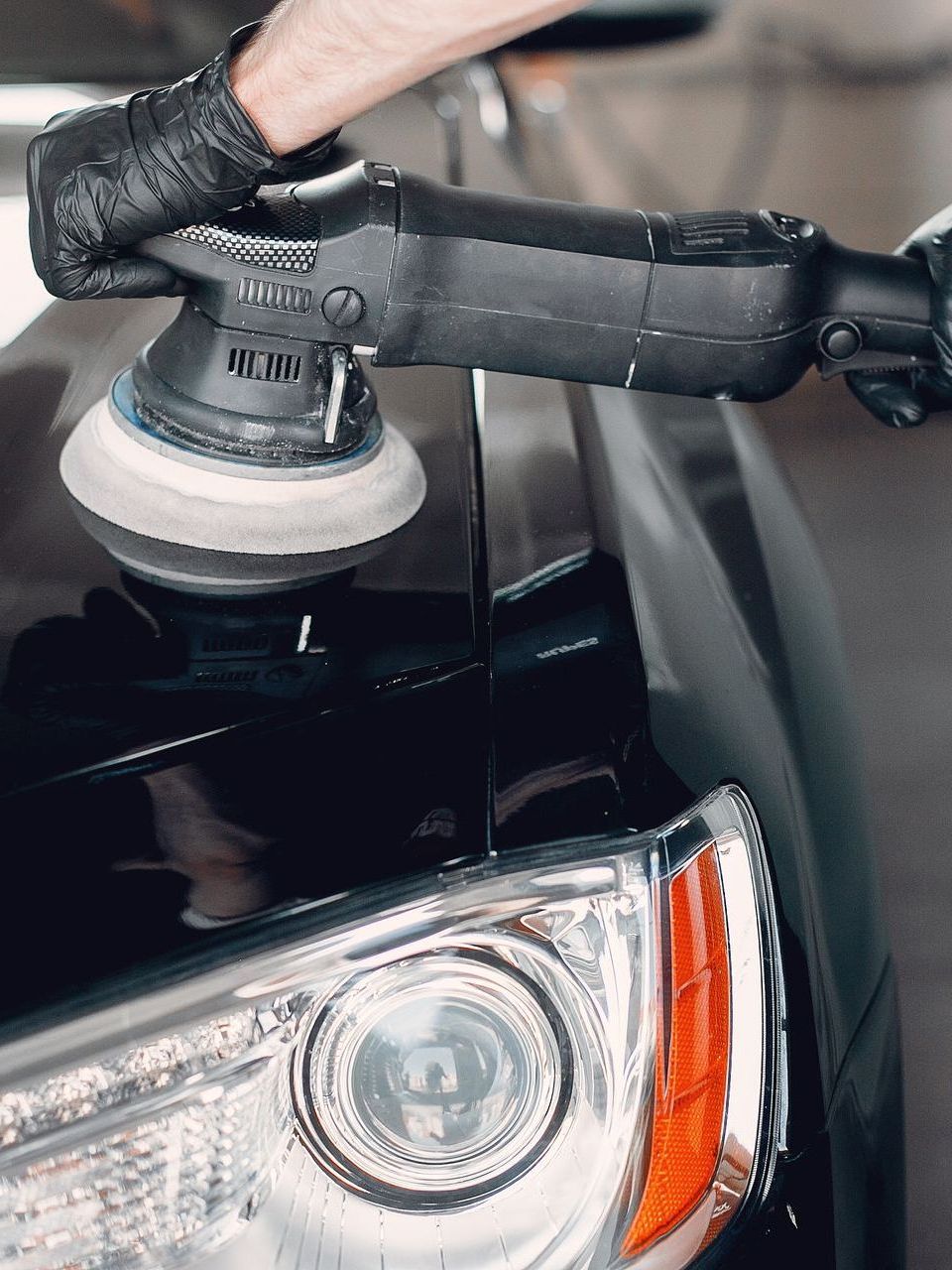 A person is polishing a car with a machine.