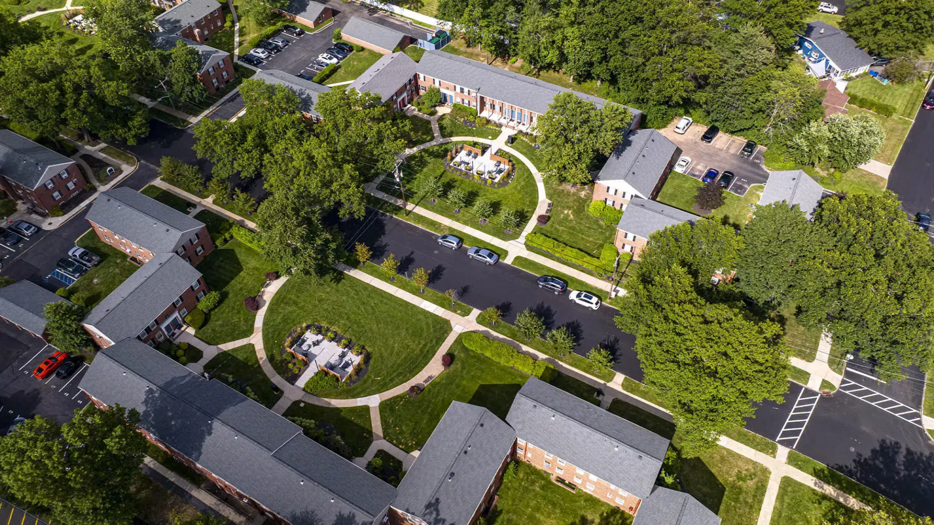 Aerial view of a landscaped apartment community with walkways, courtyards, and parking.