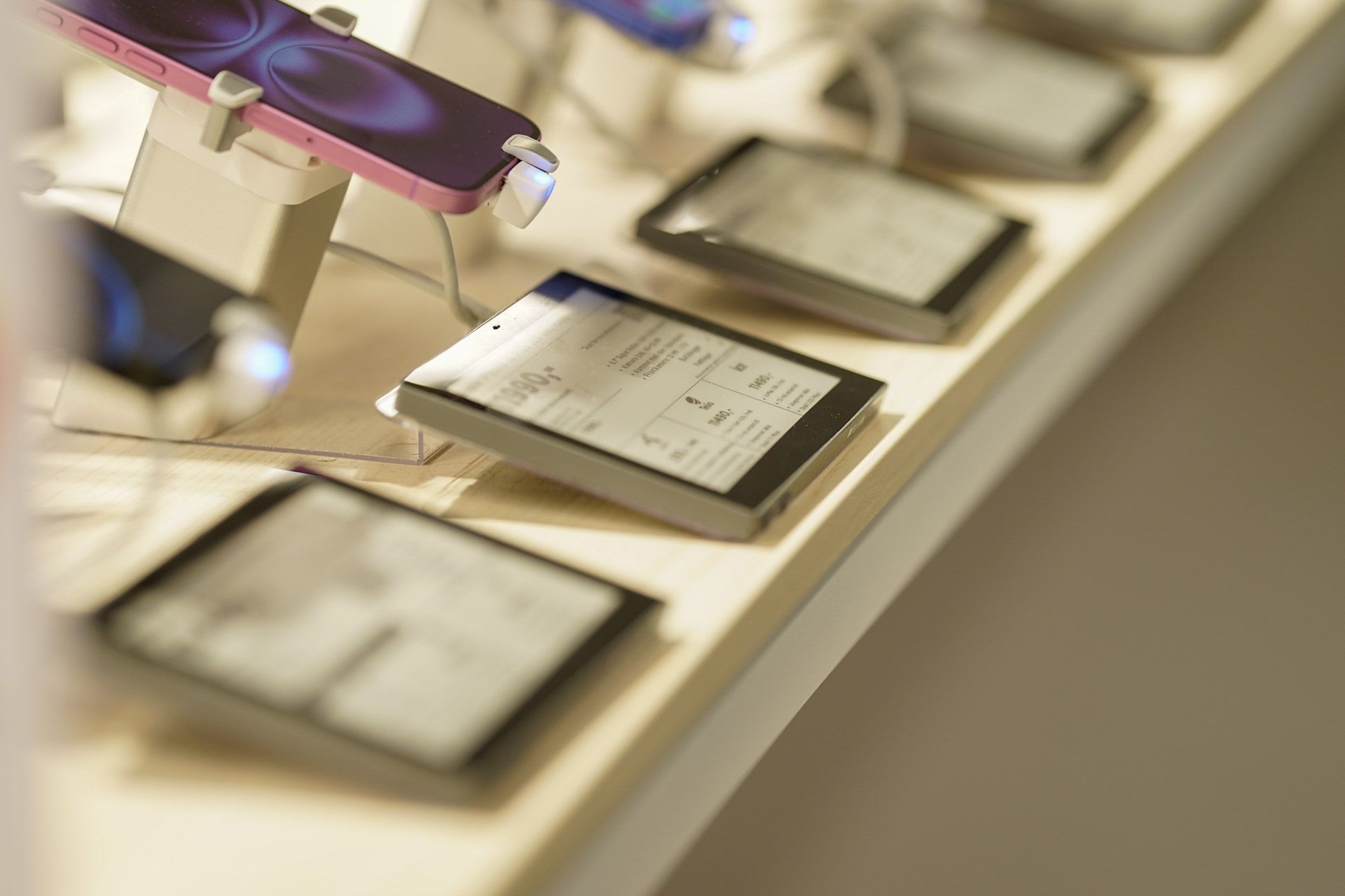 Elektroniske enheter utstilt på en disk: nettbrett, telefoner og e-lesere.