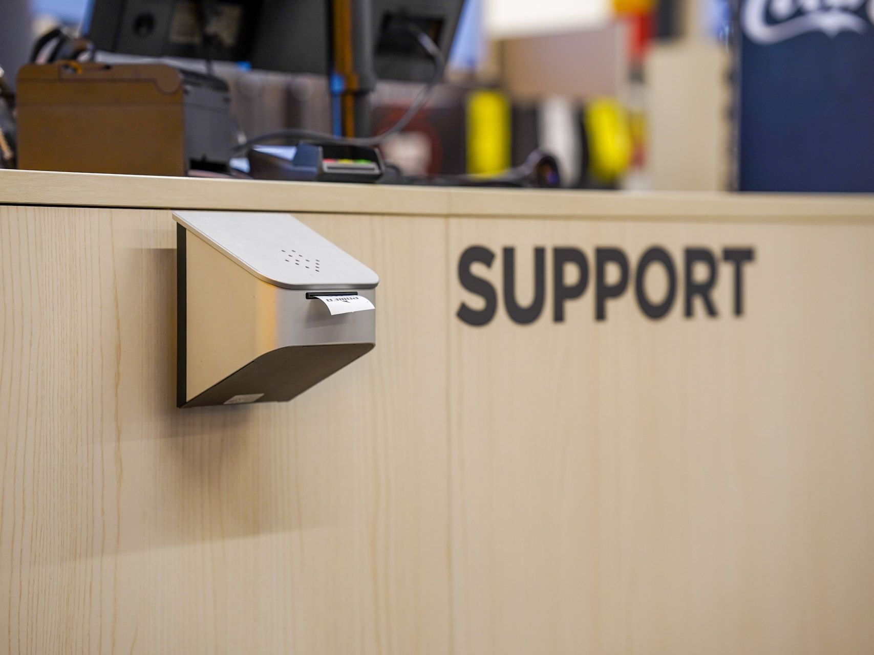 Sølvkvitteringsskriver på en tredisk merket «SUPPORT».