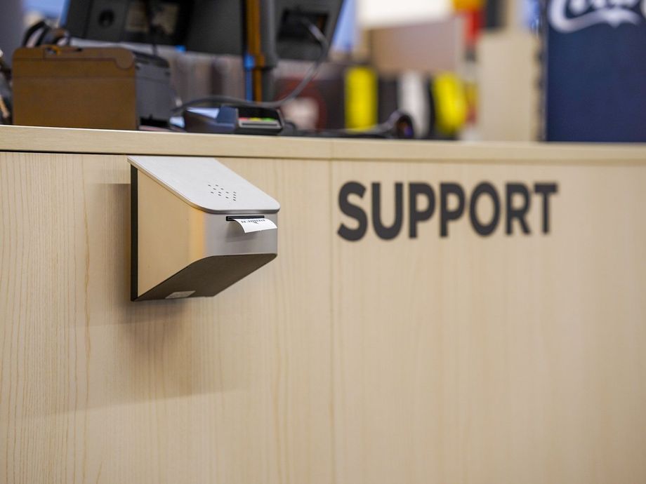 Sølvkvitteringsskriver på en tredisk merket «SUPPORT».