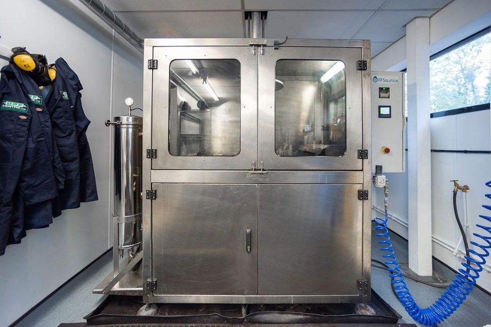 A Stainless Steel Machine Is Sitting In A Room With Jackets Hanging On The Wall — DPF Centre In Rutherford, NSW