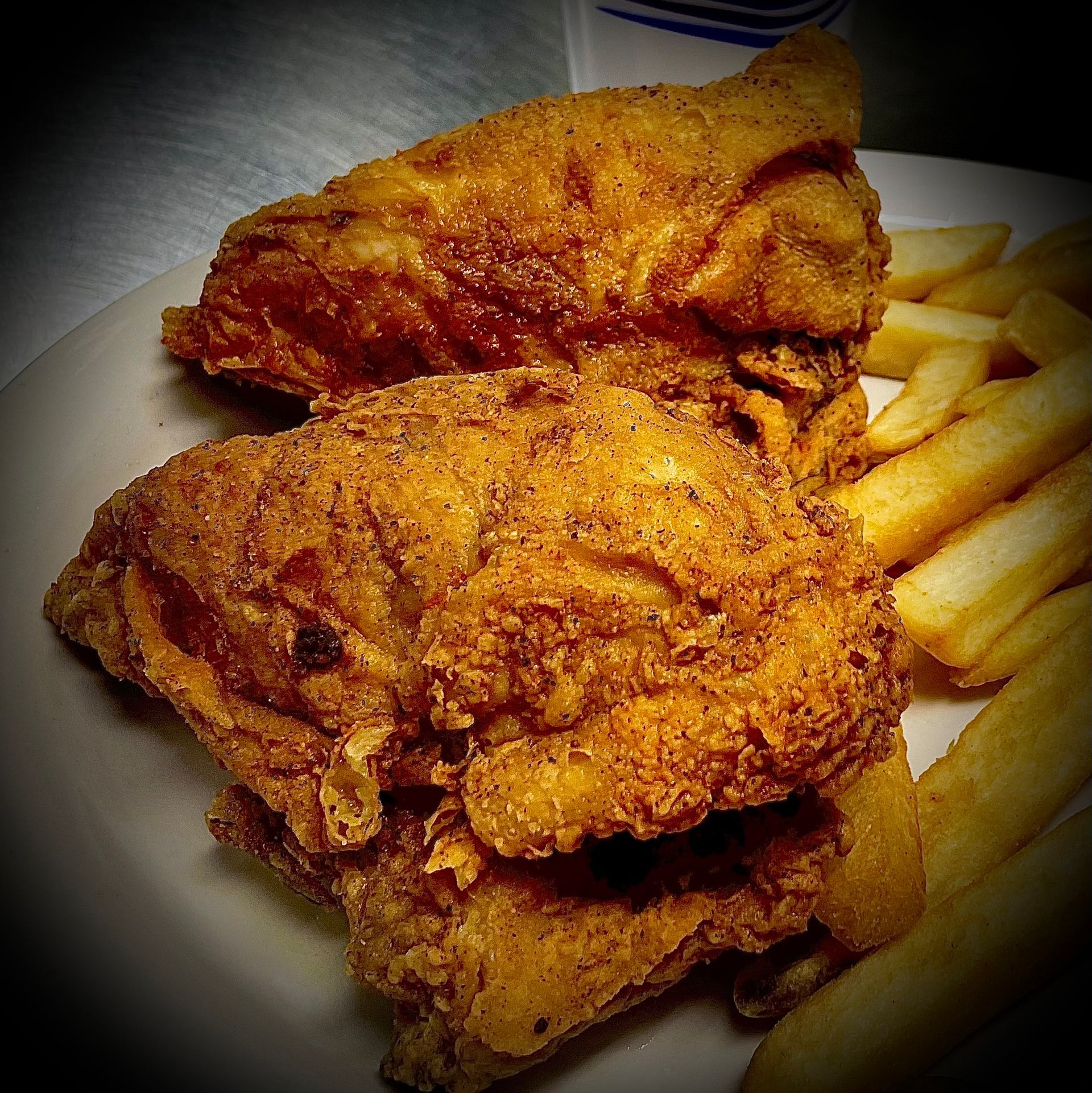 Fried chicken and french fries on a white plate