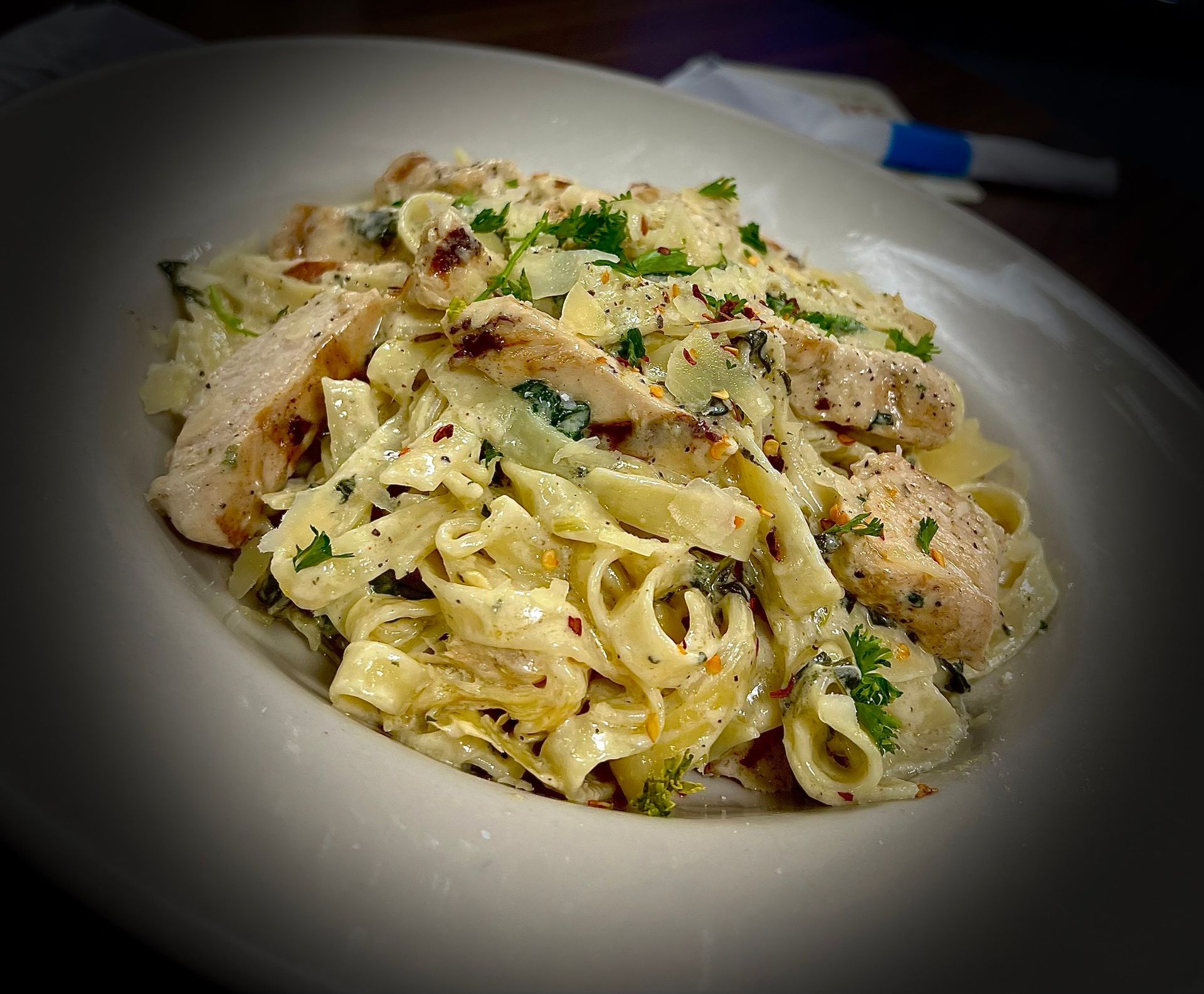 A close up of a plate of pasta with chicken