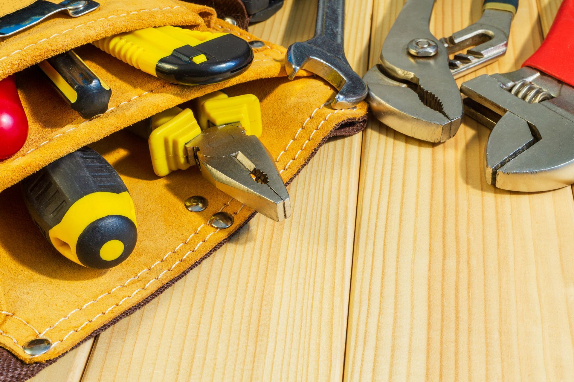 Close-up of HVAC and plumbing tools on a wooden table.