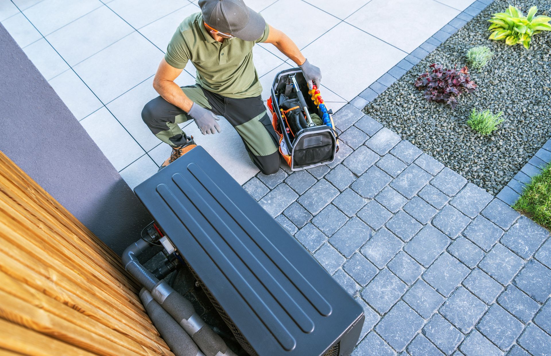 HVAC technician servicing an outdoor air conditioning unit at a coastal home to improve efficiency.