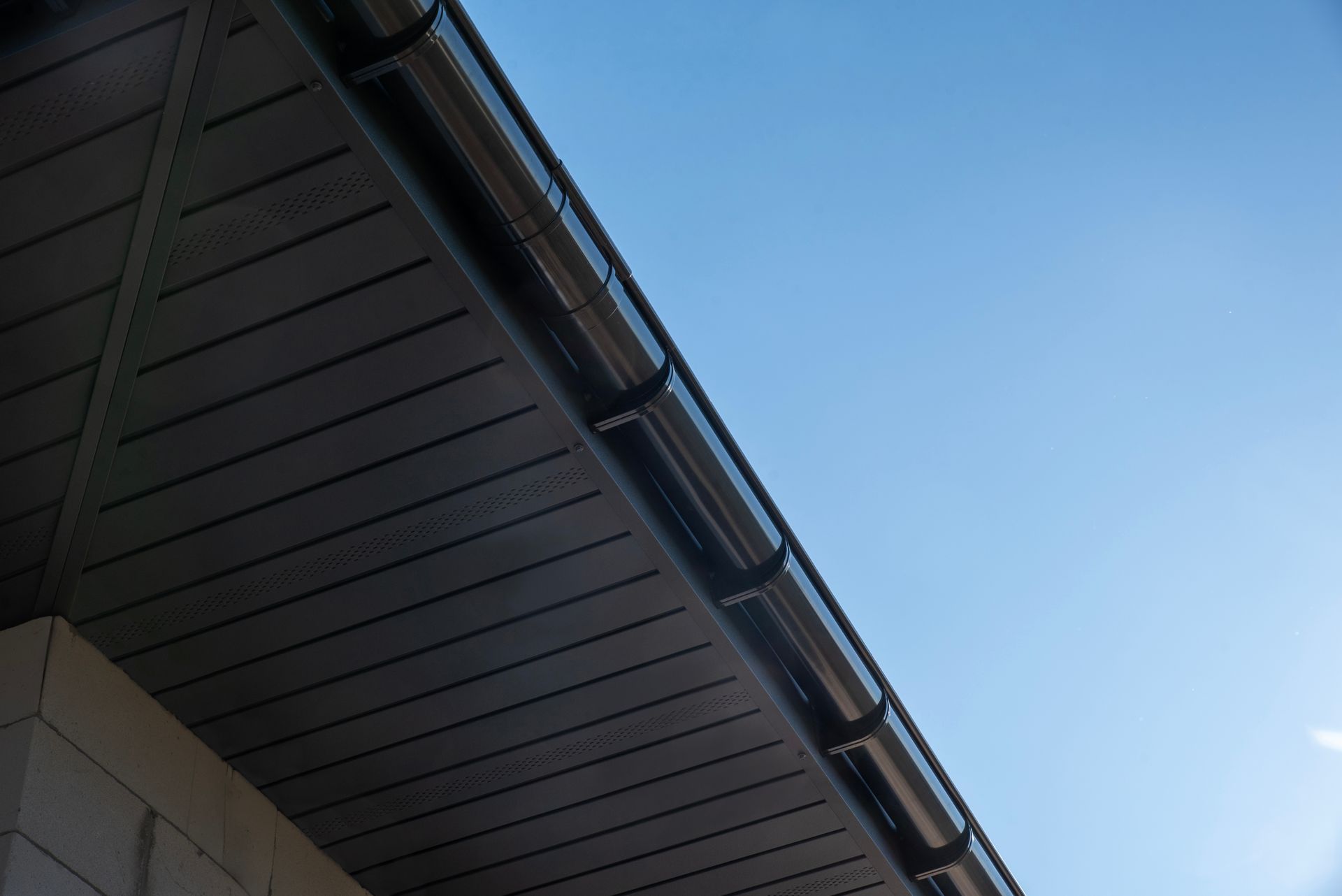 Close-up of a house roof eave against a clear blue sky Close-up of a house roof eave against a clear blue sky