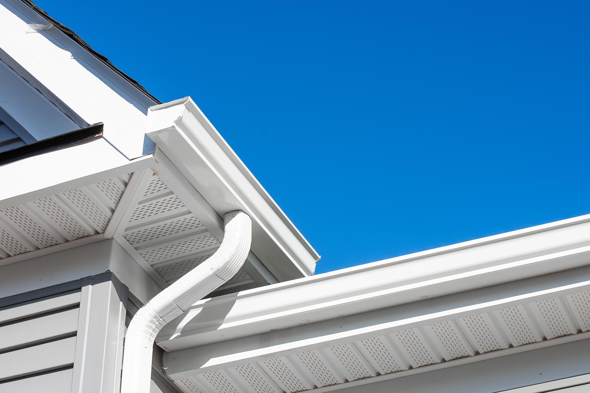 White house eaves and gutter against a bright blue sky White house eaves and gutter against a bright blue sky