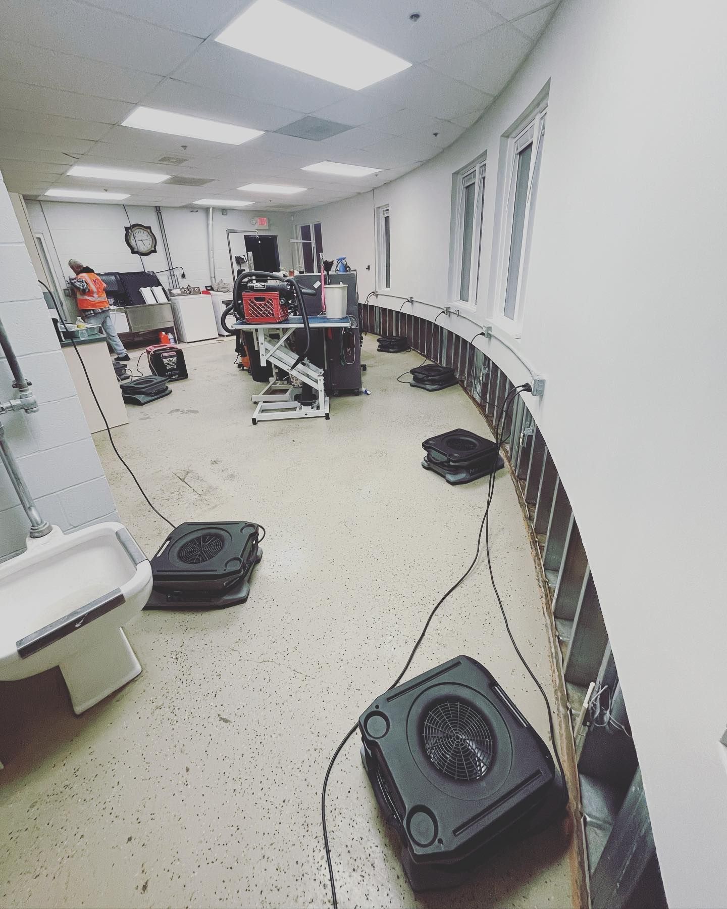 Interior view of a curved room with construction equipment. Walls are partially dismantled. Floor is light-colored.
