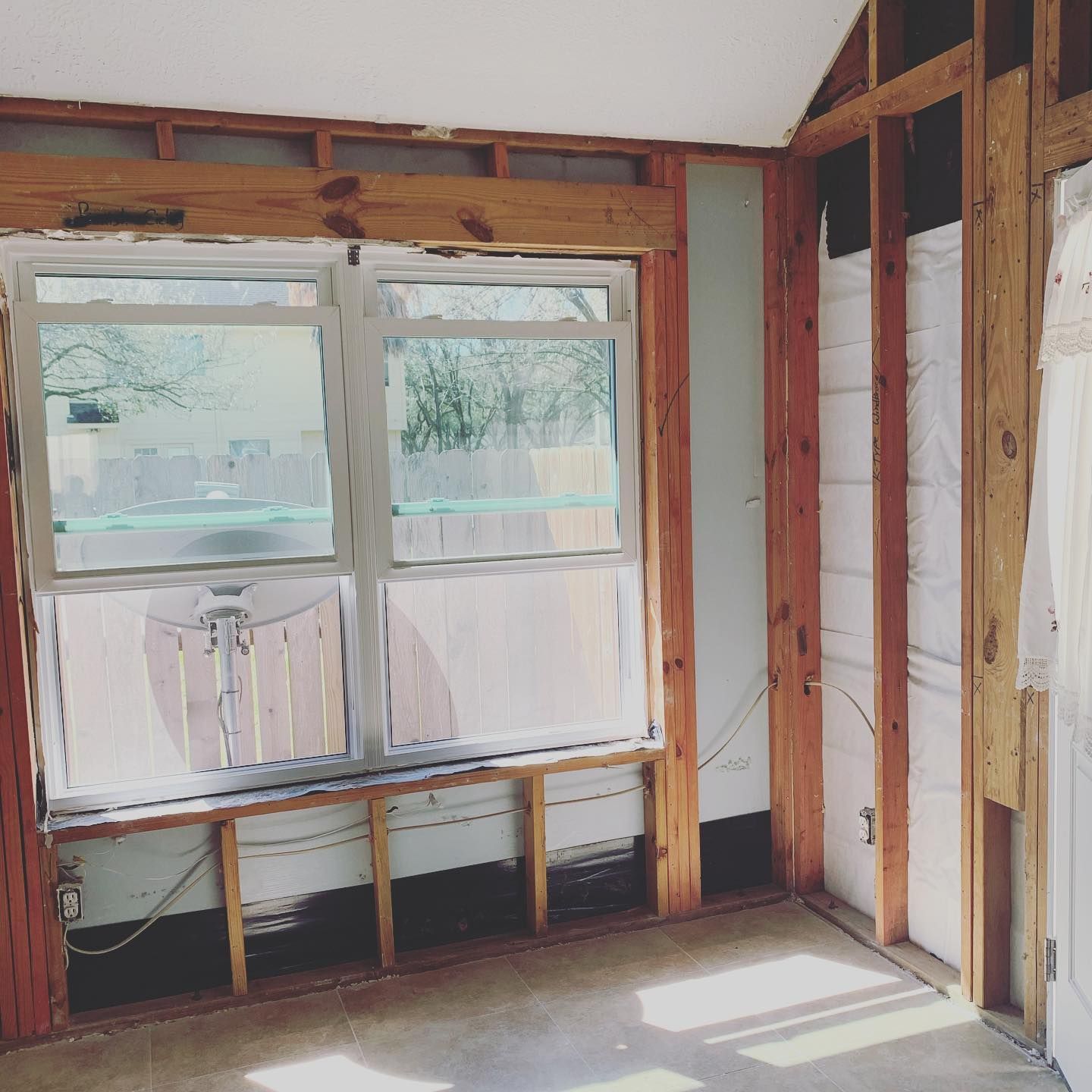 Interior room with wooden framing, window, insulation, and unfinished walls.