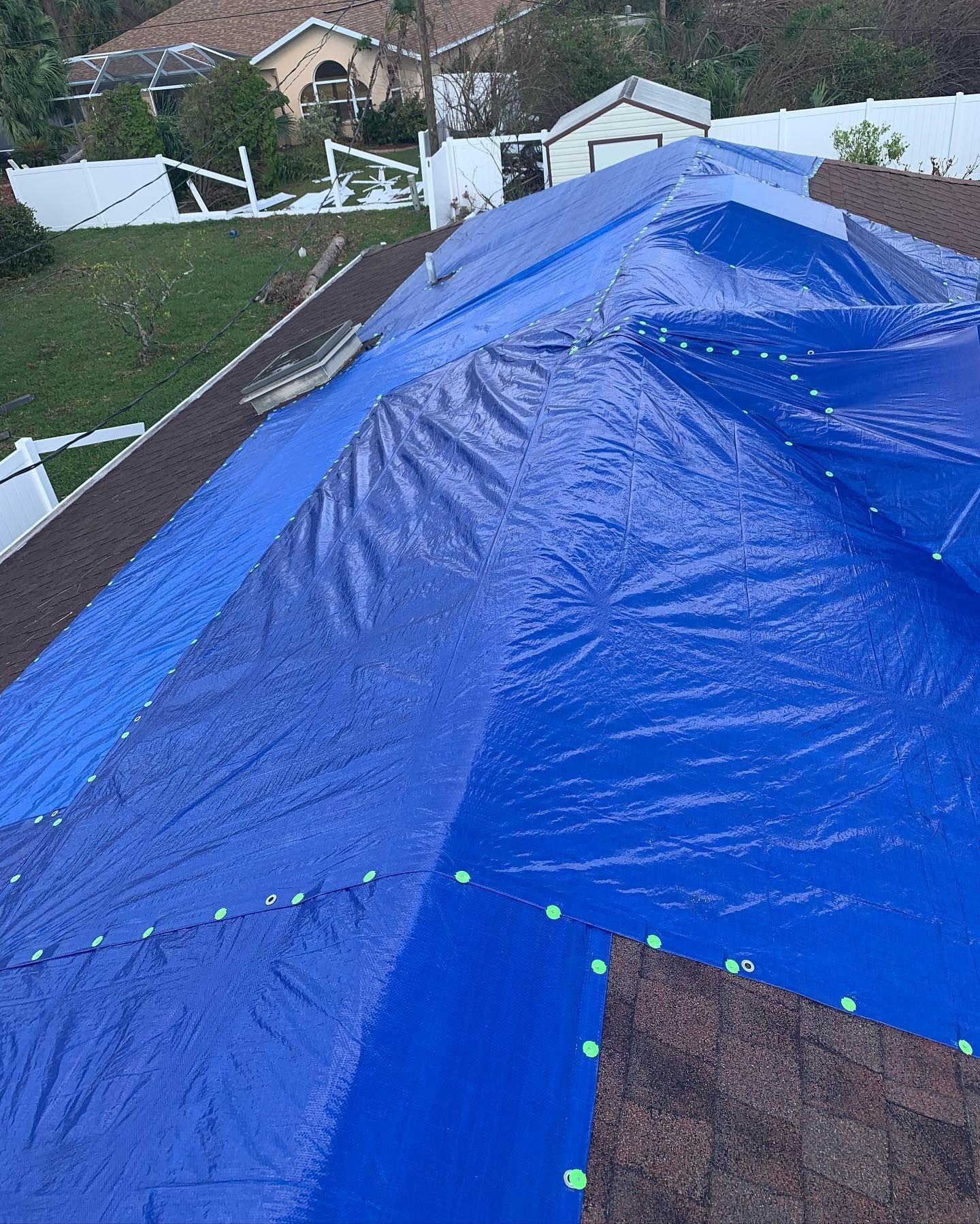 Blue tarp covering a damaged rooftop, protecting the house from weather damage.