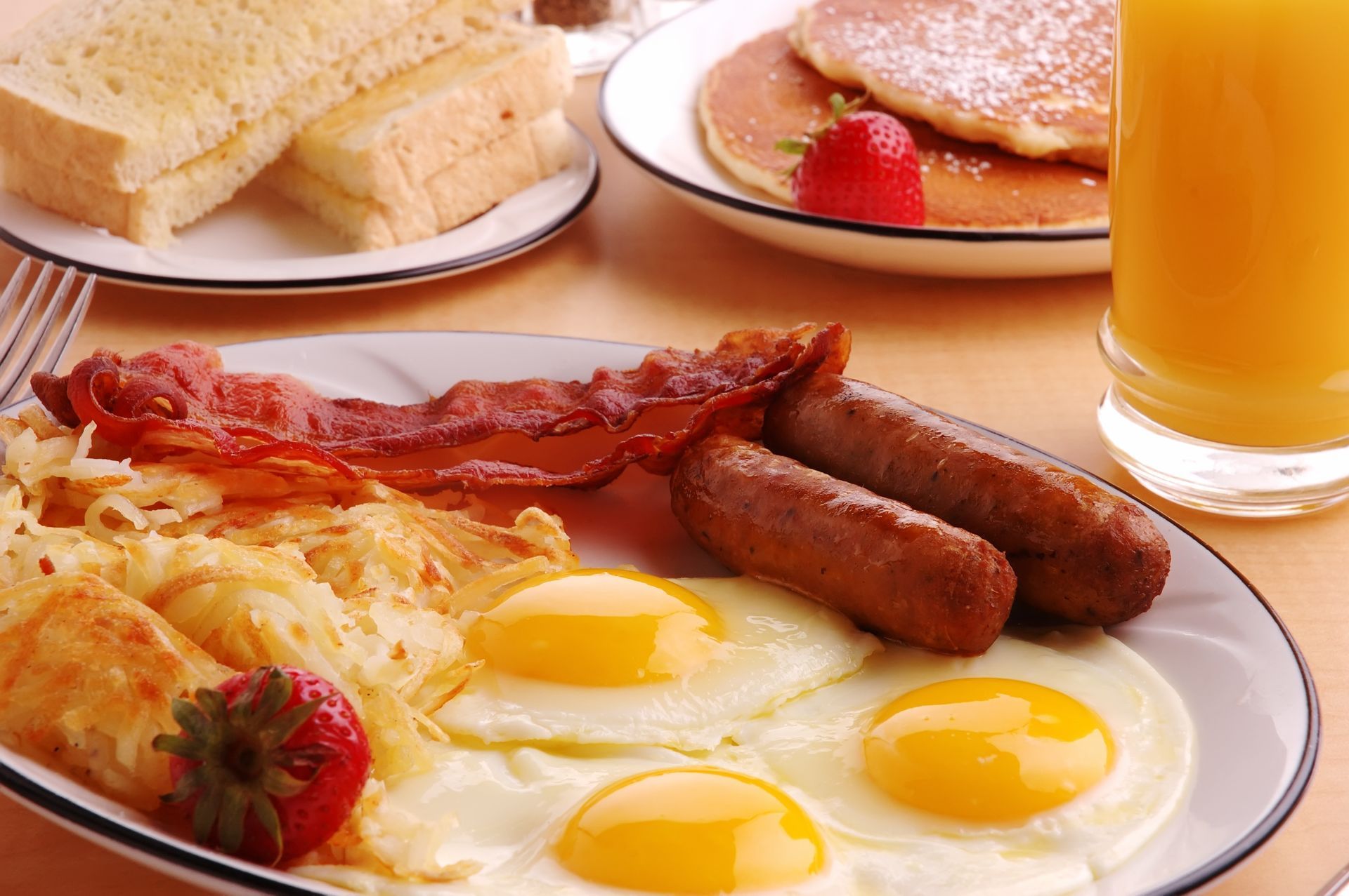 A plate of food with eggs bacon and sausage on it