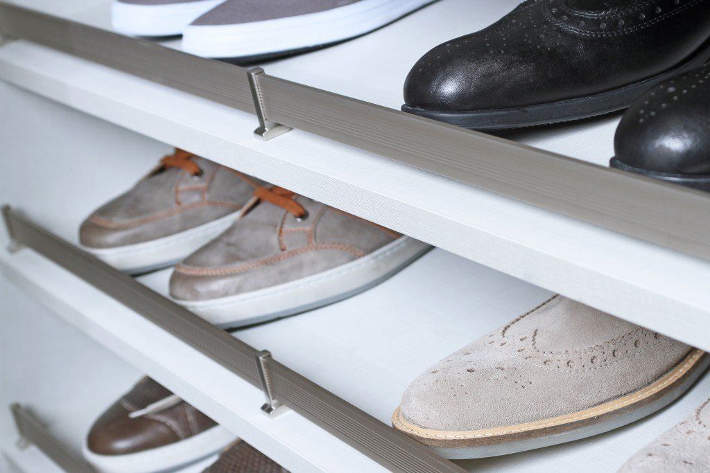 Shoes arranged on white closet shelves, including brown, black, and beige pairs