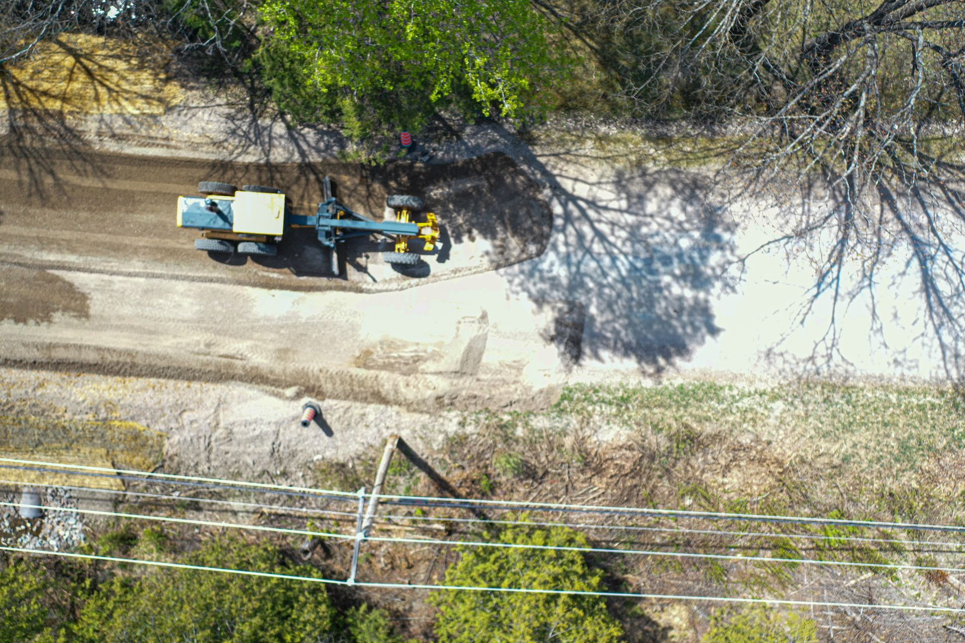 Une vue aérienne d'un tracteur sur un chemin de terre.
