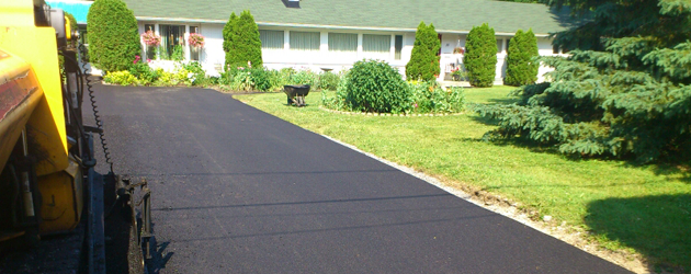 Une allée est en train d'être pavée devant une maison.