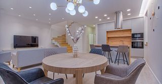 A living room with a round table and chairs in it.