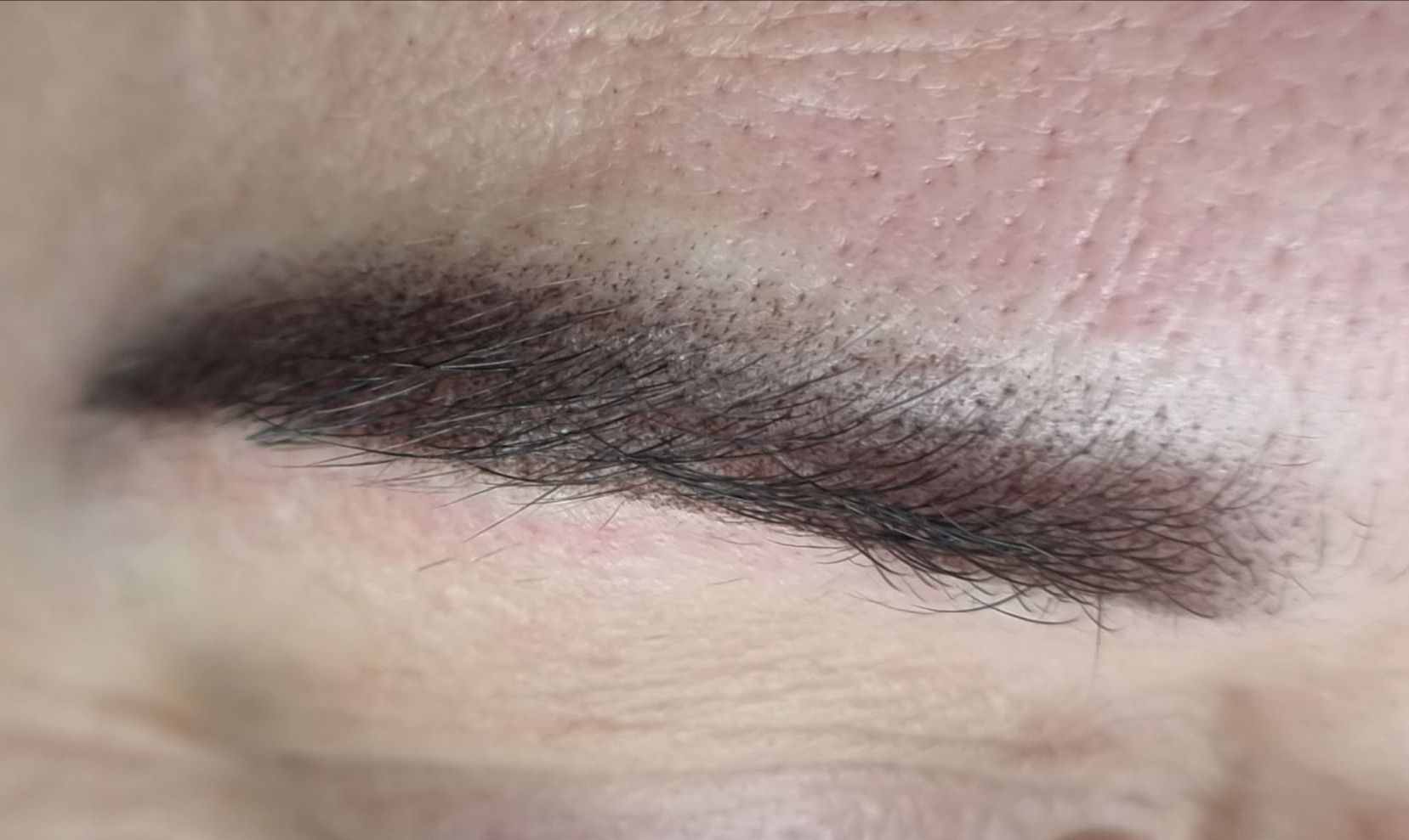 Eine Nahaufnahme der Augenbraue einer Frau mit einem Schatten darauf.