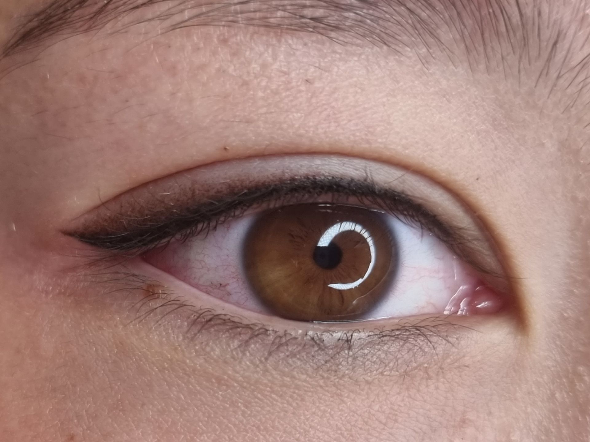 Eine Nahaufnahme des braunen Auges einer Frau mit Eyeliner.