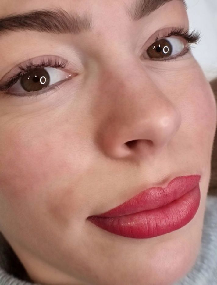 Eine Nahaufnahme des Gesichts einer Frau mit rotem Lippenstift.