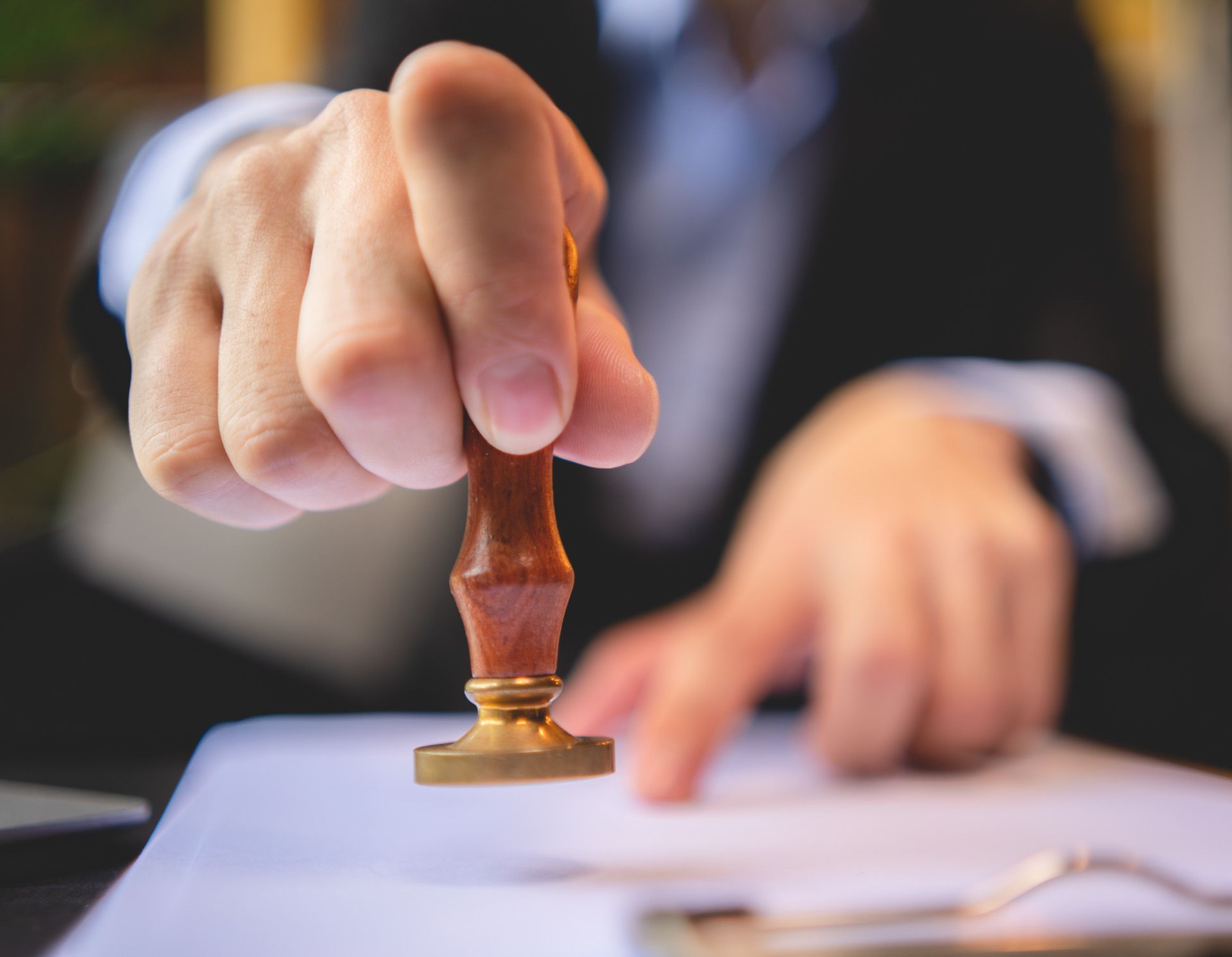 A man is stamping a document with a wooden stamp.