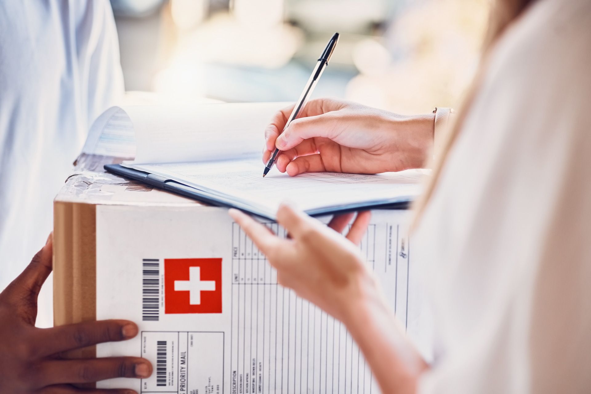 A person is signing a document next to a box with a swiss flag on it.