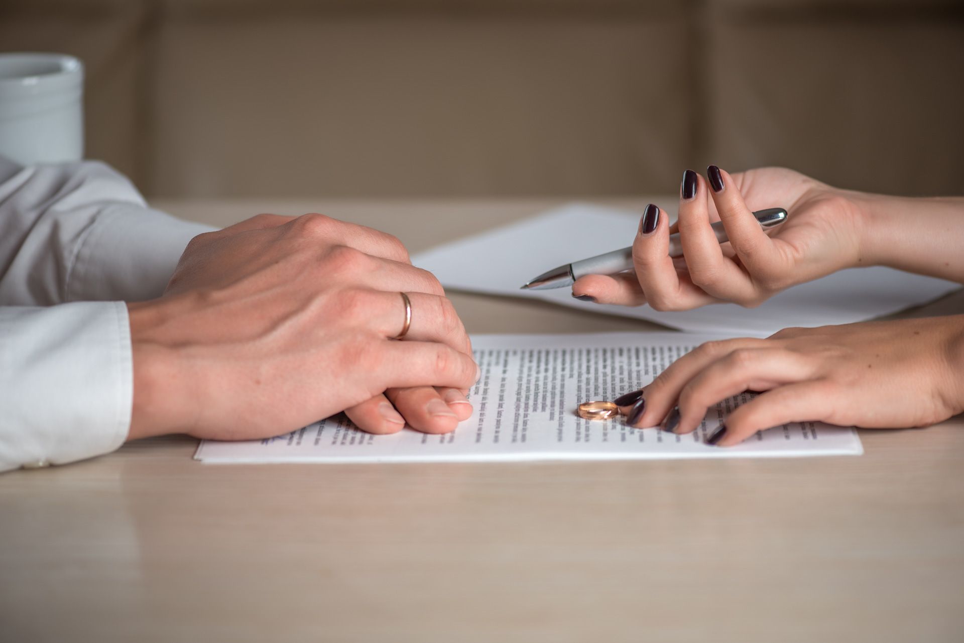 A man and a woman are sitting at a table signing a divorce agreement.