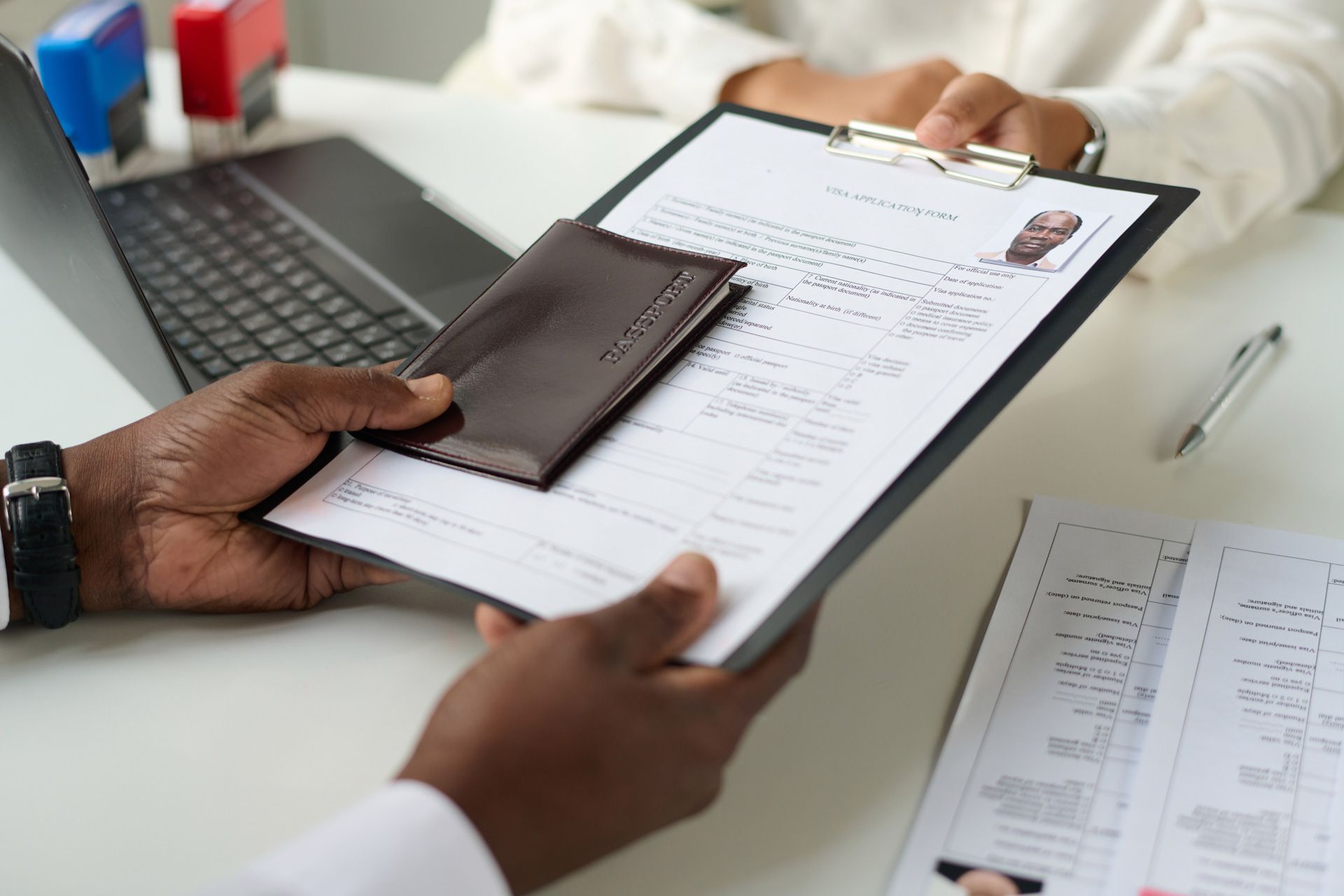 A man is holding a clipboard with a resume and a wallet on it.
