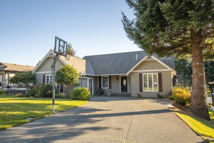 Wide residential concrete driveway with basketball hoop and ample parking in Bushnell
