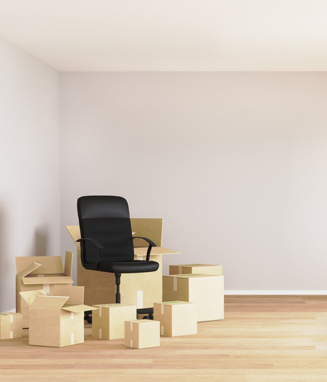 A chair is sitting on top of a pile of cardboard boxes.