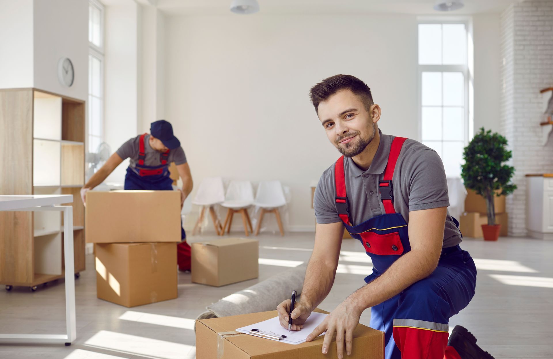 A man is kneeling down next to a box in a living room.